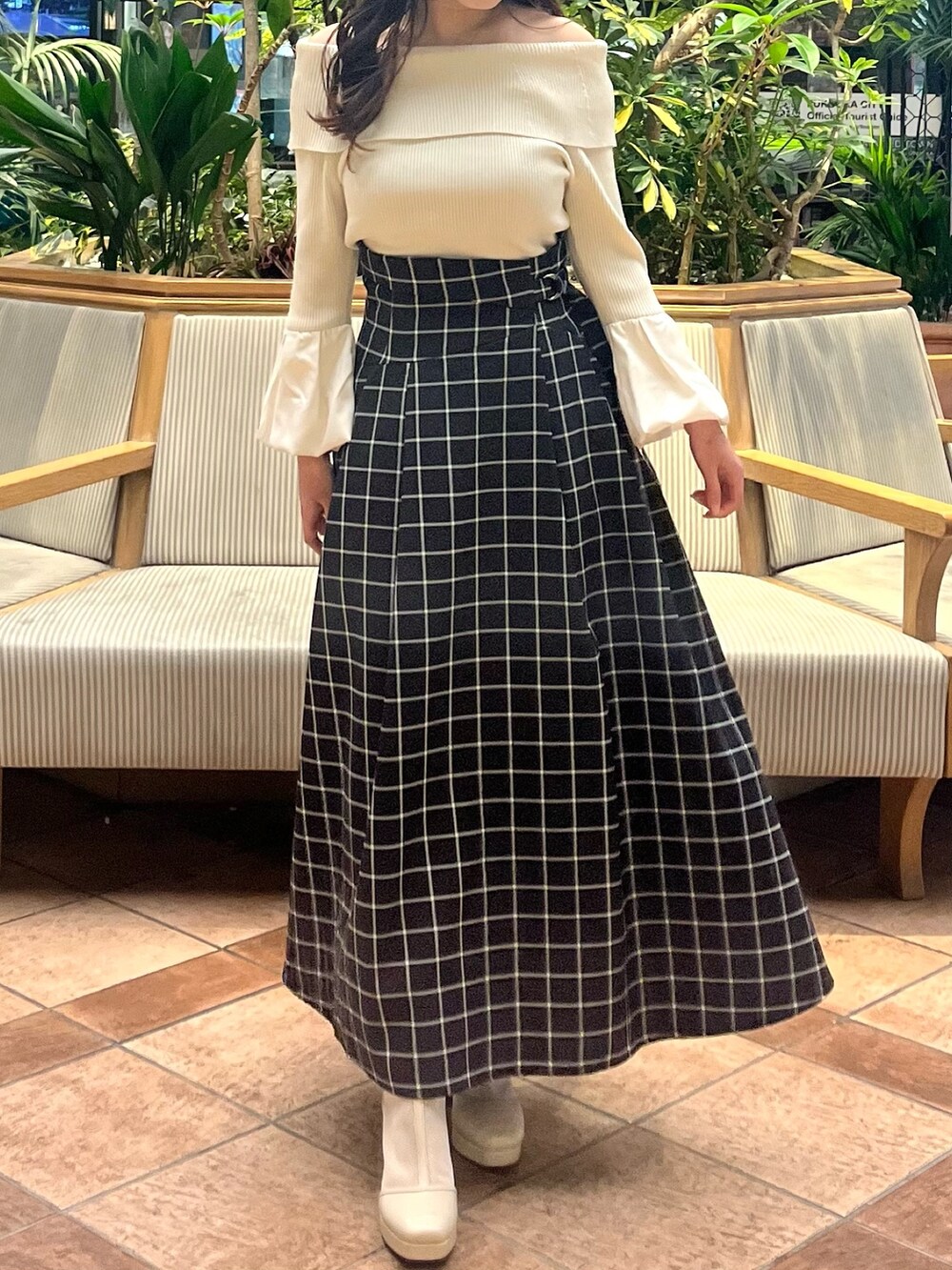 ホワイト系のニット/セーター、ブラック系のスカート、ホワイト系のブーツを着用したレディースの春コーディネートの4枚目の写真