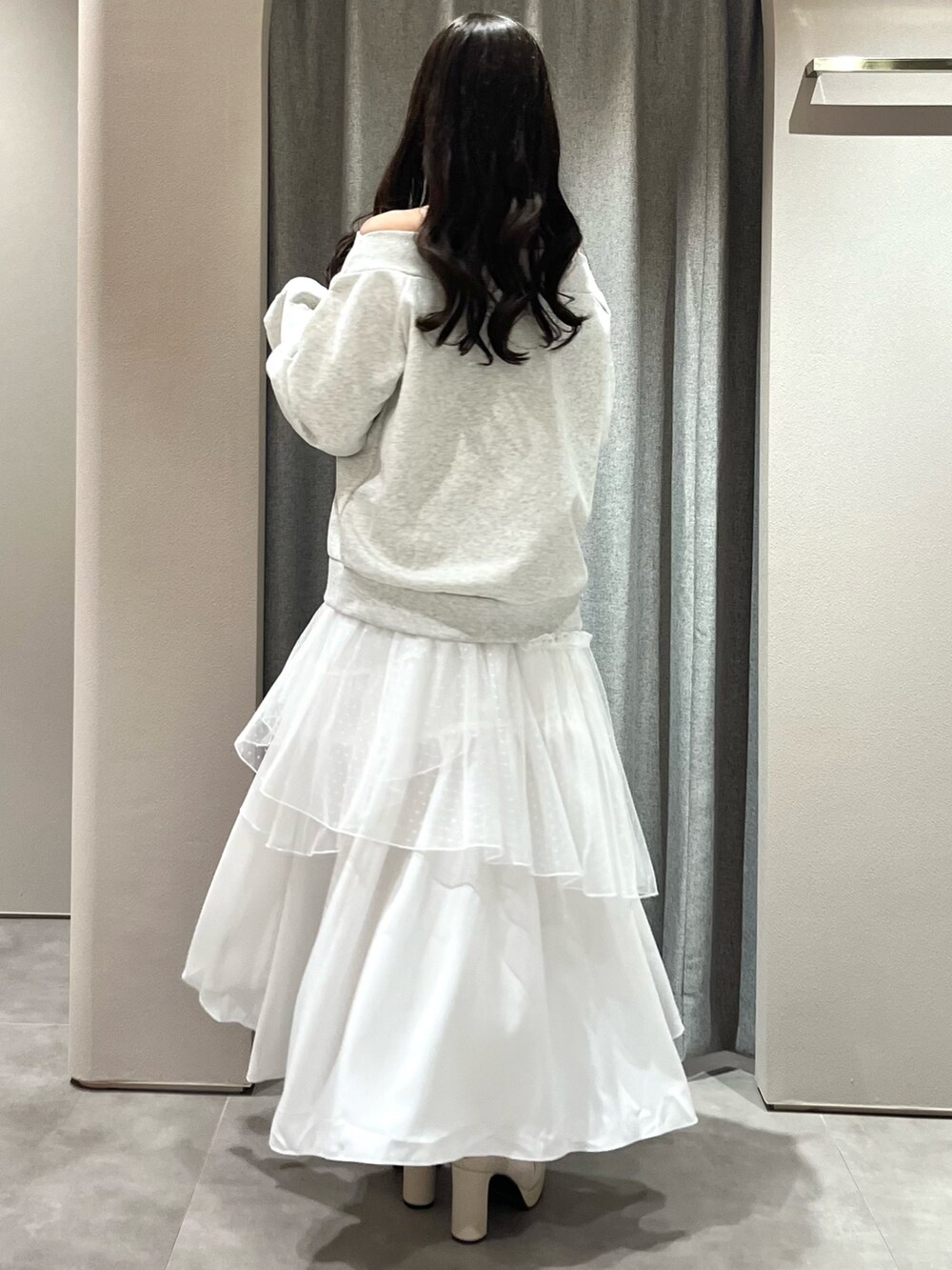 グレー系のスウェット、ホワイト系のスカート、ホワイト系のブーツを着用したレディースの春コーディネートの8枚目の写真