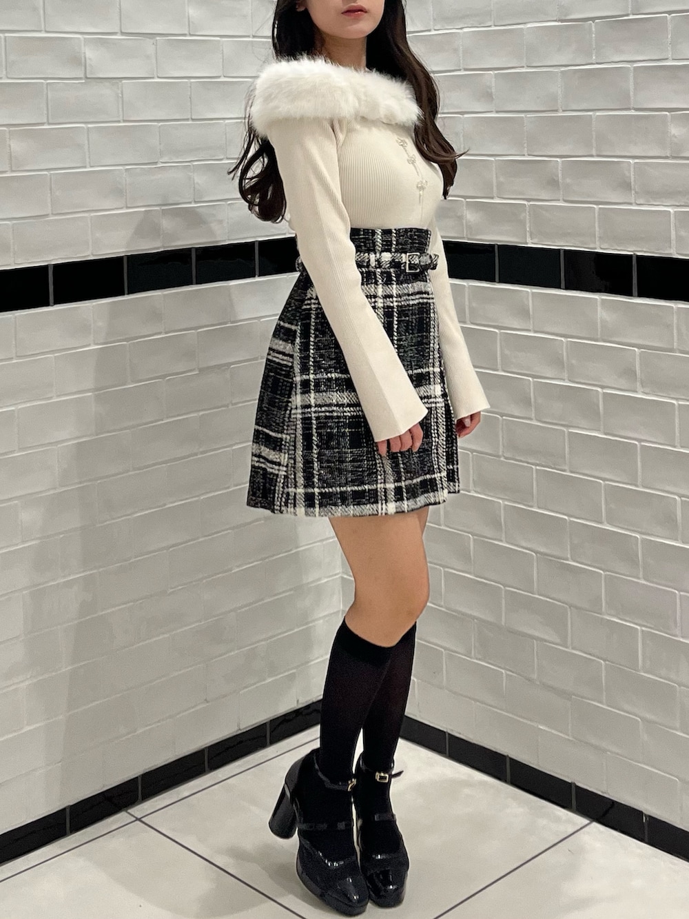 ベージュ系のニット/セーター、ブラック系のスカート、ブラック系のパンプスを着用したレディースの冬コーディネートの6枚目の写真