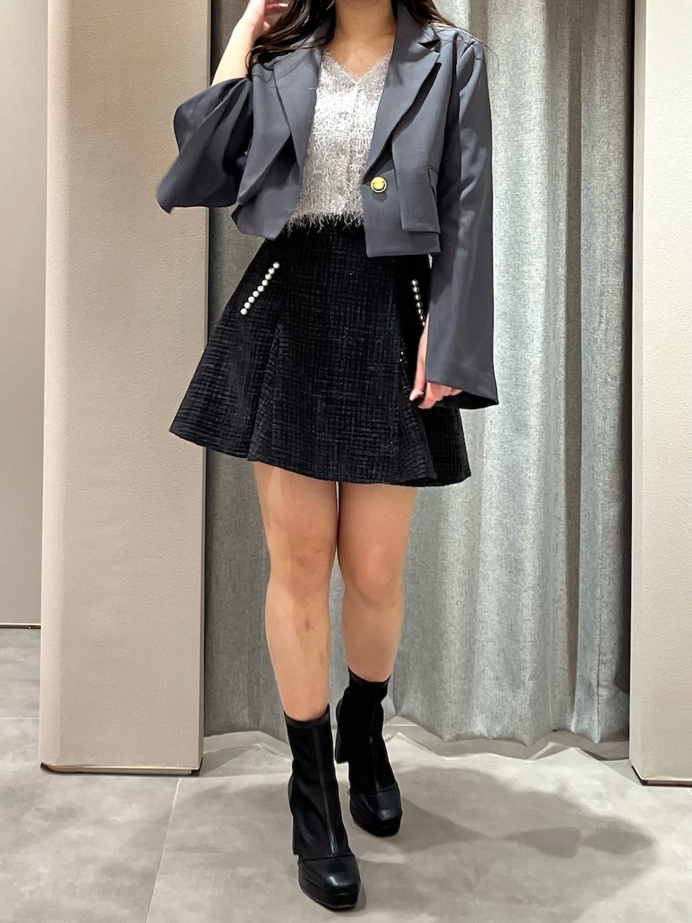 グレー系のテーラードジャケット、グレー系のニット/セーター、ブラック系のスカートを着用したレディースの春コーディネートの4枚目の写真