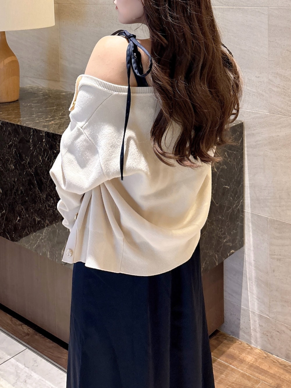 ブルー系のワンピース、ホワイト系のカーディガン/ボレロ、ブラック系のパンプスを着用したレディースの秋コーディネートの9枚目の写真