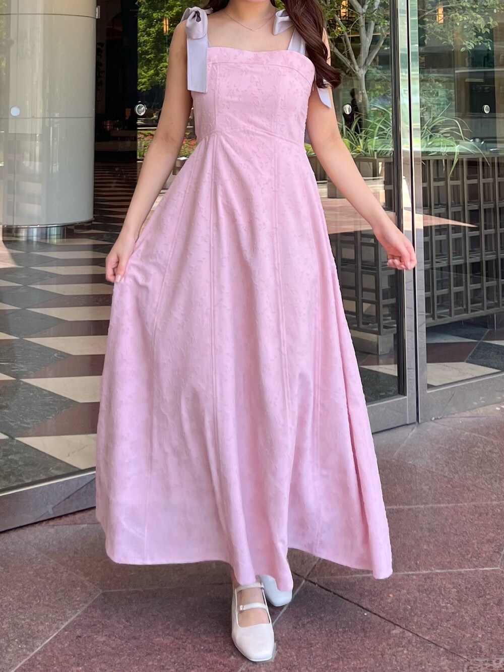 ピンク系のワンピース、ホワイト系のパンプスを着用したレディースの夏コーディネートの3枚目の写真