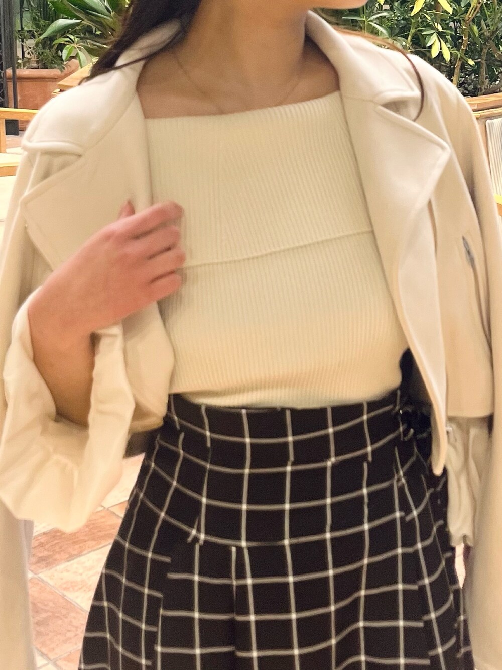 ホワイト系のライダースジャケット、ホワイト系のニット/セーター、ブラック系のスカートを着用したレディースの春コーディネートの9枚目の写真