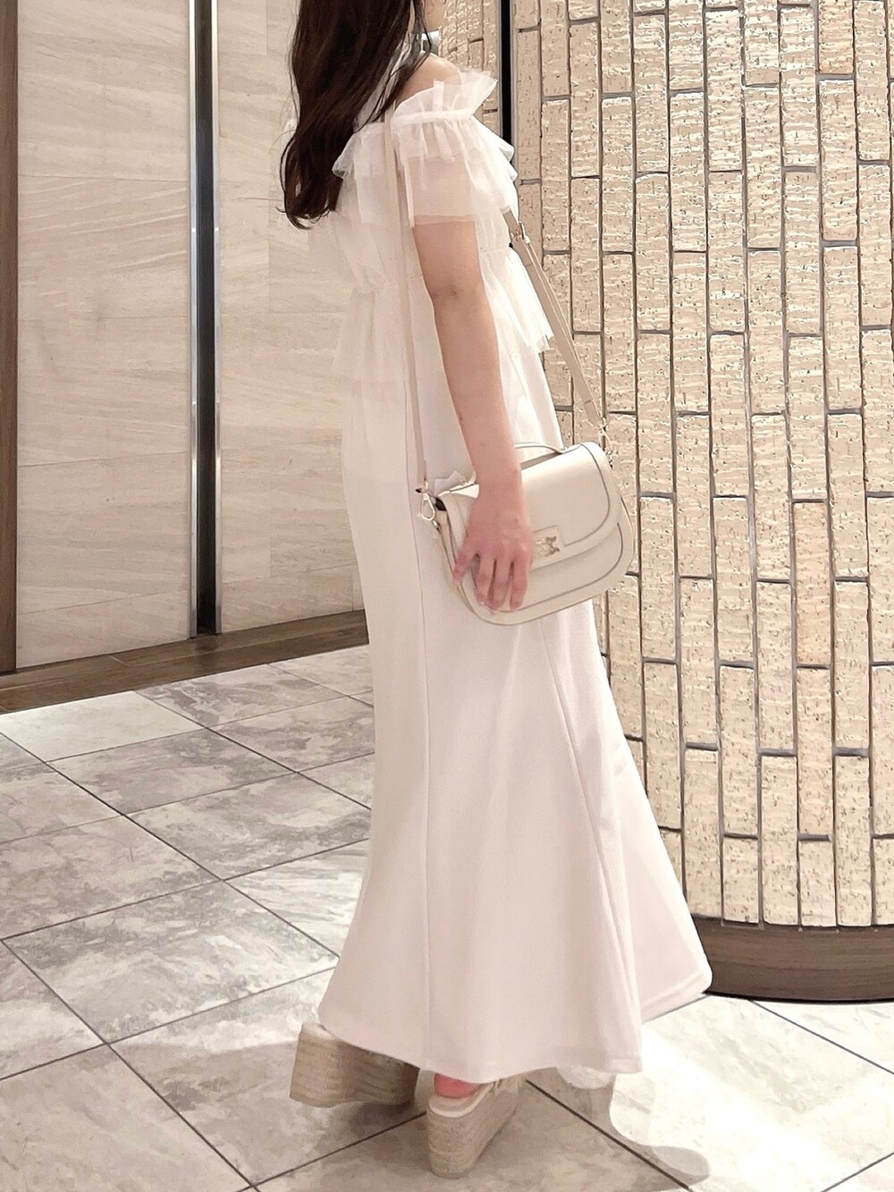 ホワイト系のワンピース、ホワイト系のハンドバッグ、オレンジ系のサンダルを着用したレディースの夏コーディネートの4枚目の写真