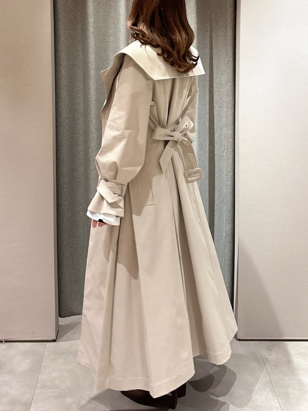 ブラック系のTシャツ/カットソー、ベージュ系のトレンチコート、グレー系のスカートを着用したレディースの春コーディネートの6枚目の写真