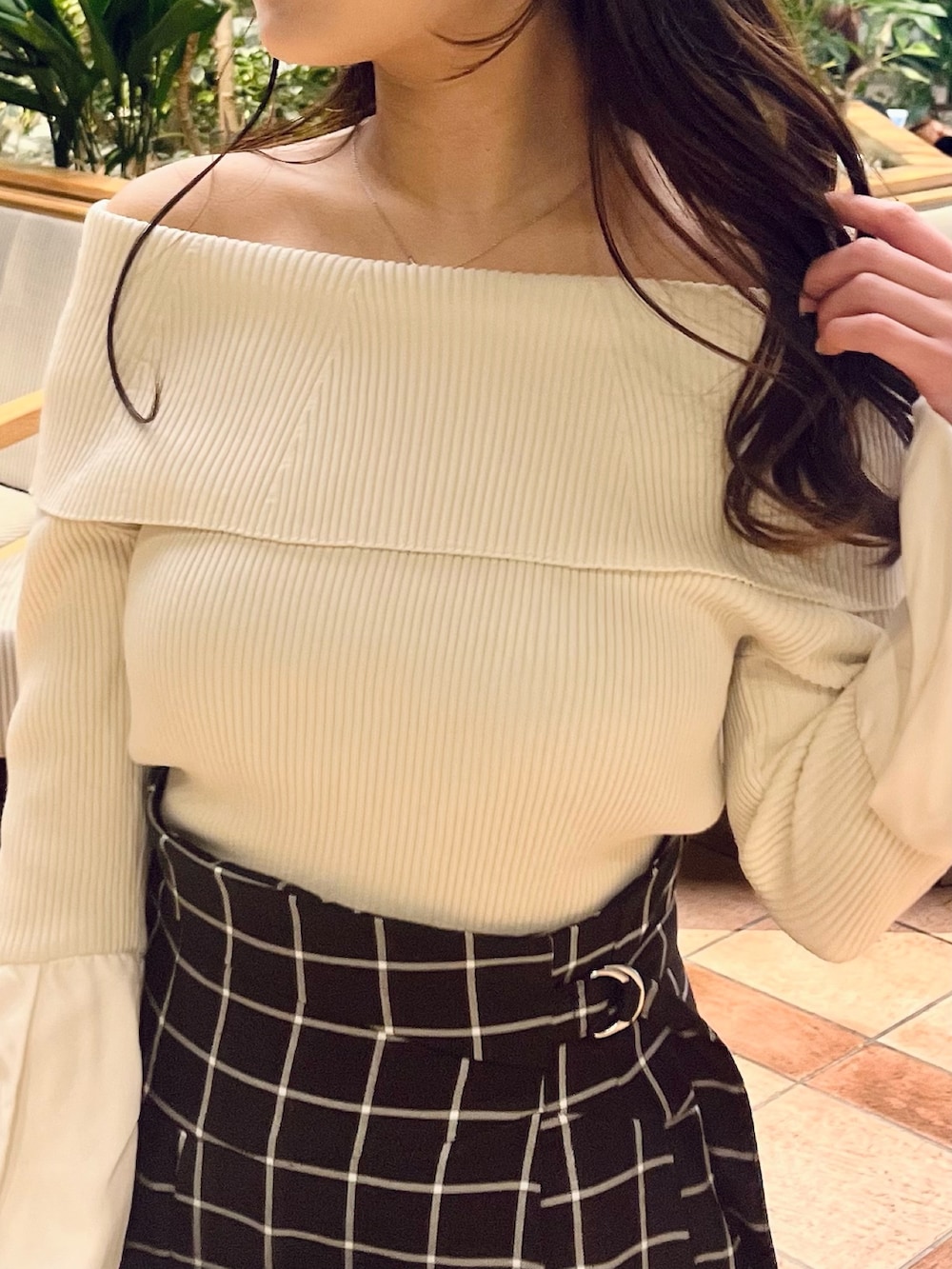 ホワイト系のニット/セーター、ブラック系のスカート、ホワイト系のブーツを着用したレディースの春コーディネートの9枚目の写真