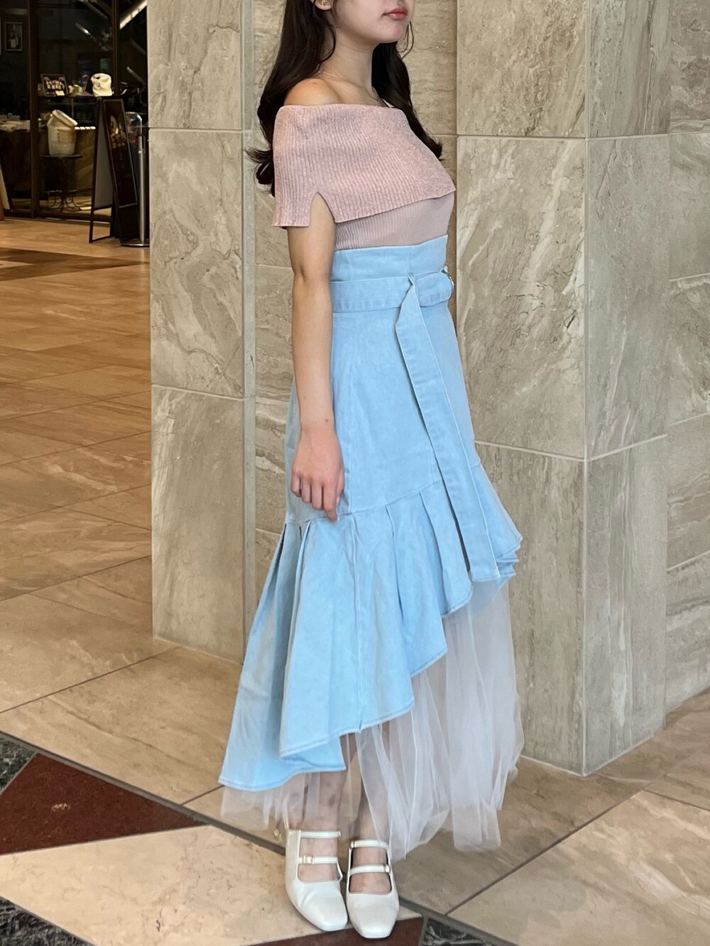 ピンク系のニット/セーター、ブルー系のスカート、ホワイト系のパンプスを着用したレディースの夏コーディネートの6枚目の写真