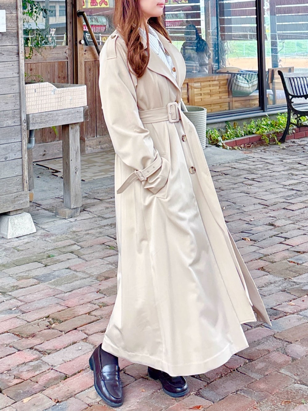 ベージュ系のトレンチコートを着用したレディースの春コーディネートの6枚目の写真