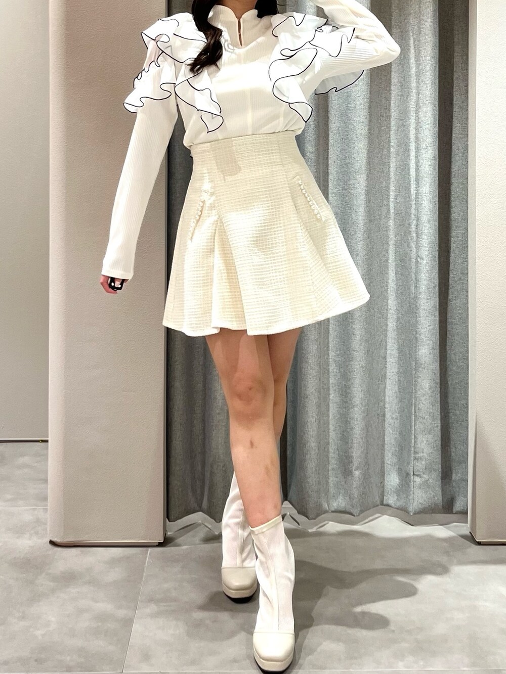 ホワイト系のTシャツ/カットソー、ホワイト系のスカート、ホワイト系のブーツを着用したレディースの春コーディネートの2枚目の写真