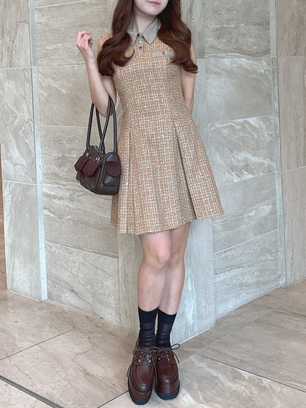 イエロー系のワンピース、ブラウン系のボストンバッグ、ブラウン系のローファーを着用したレディースの秋コーディネートの5枚目の写真