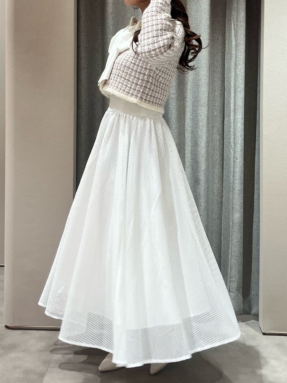 パープル系のノーカラージャケット、ホワイト系のワンピース、ホワイト系のパンプスを着用したレディースの春コーディネートの7枚目の写真