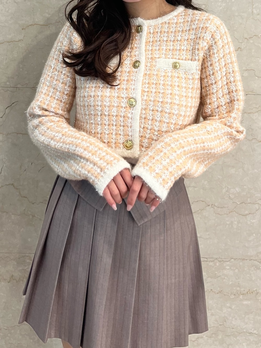 オレンジ系のノーカラージャケット、ベージュ系のスカート、ホワイト系のブーツを着用したレディースの冬コーディネートの7枚目の写真