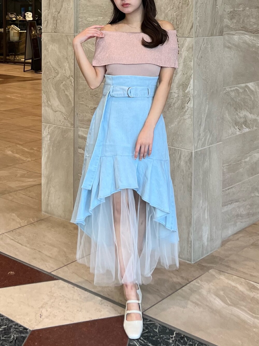 ピンク系のニット/セーター、ブルー系のスカート、ホワイト系のパンプスを着用したレディースの夏コーディネートの3枚目の写真