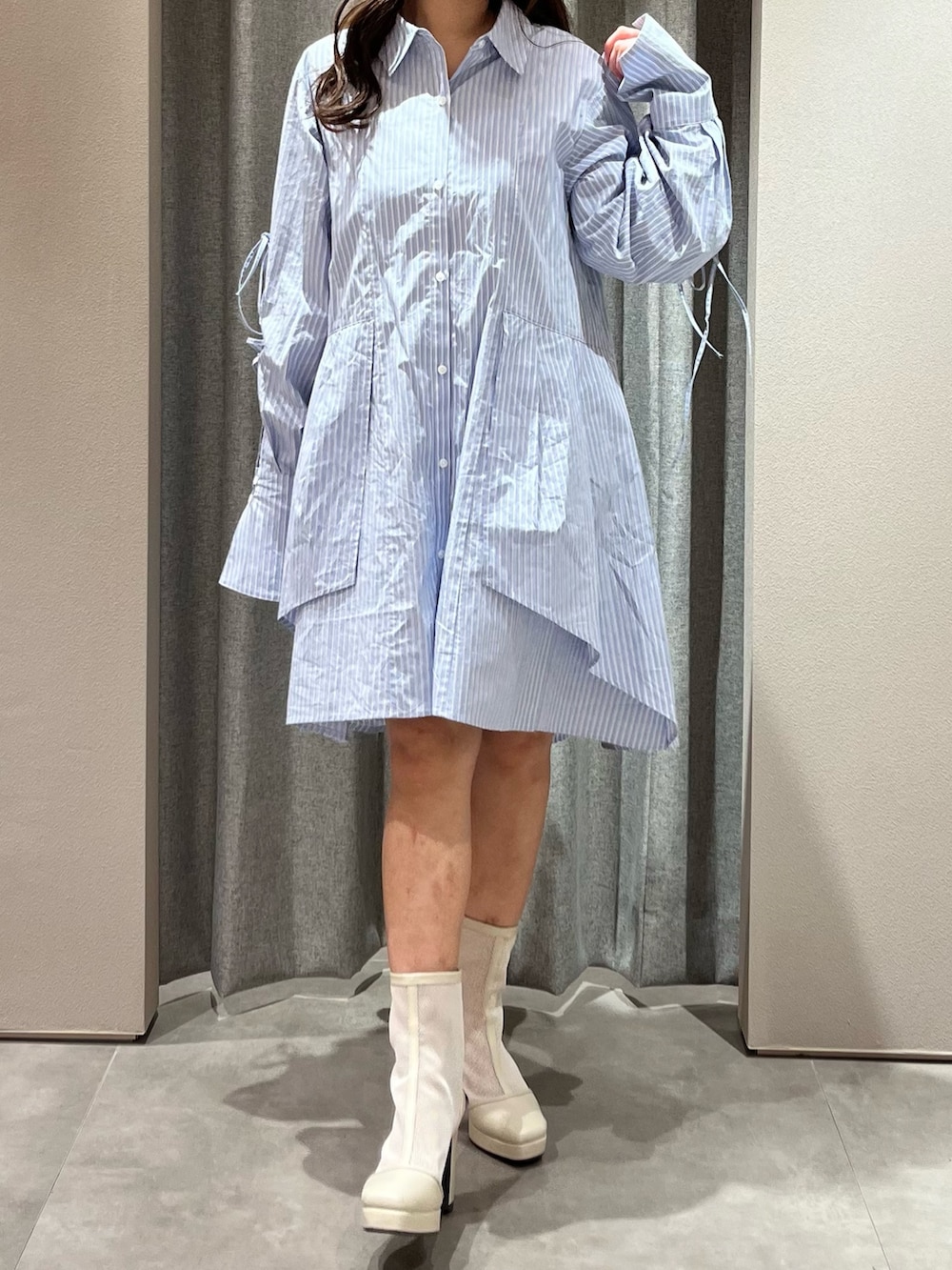 ブルー系のシャツワンピース、ホワイト系のブーツを着用したレディースの冬コーディネートの2枚目の写真