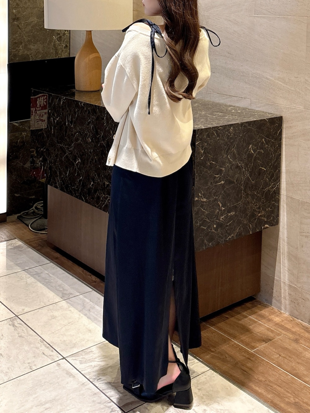 ブルー系のワンピース、ホワイト系のカーディガン/ボレロ、ブラック系のパンプスを着用したレディースの秋コーディネートの6枚目の写真