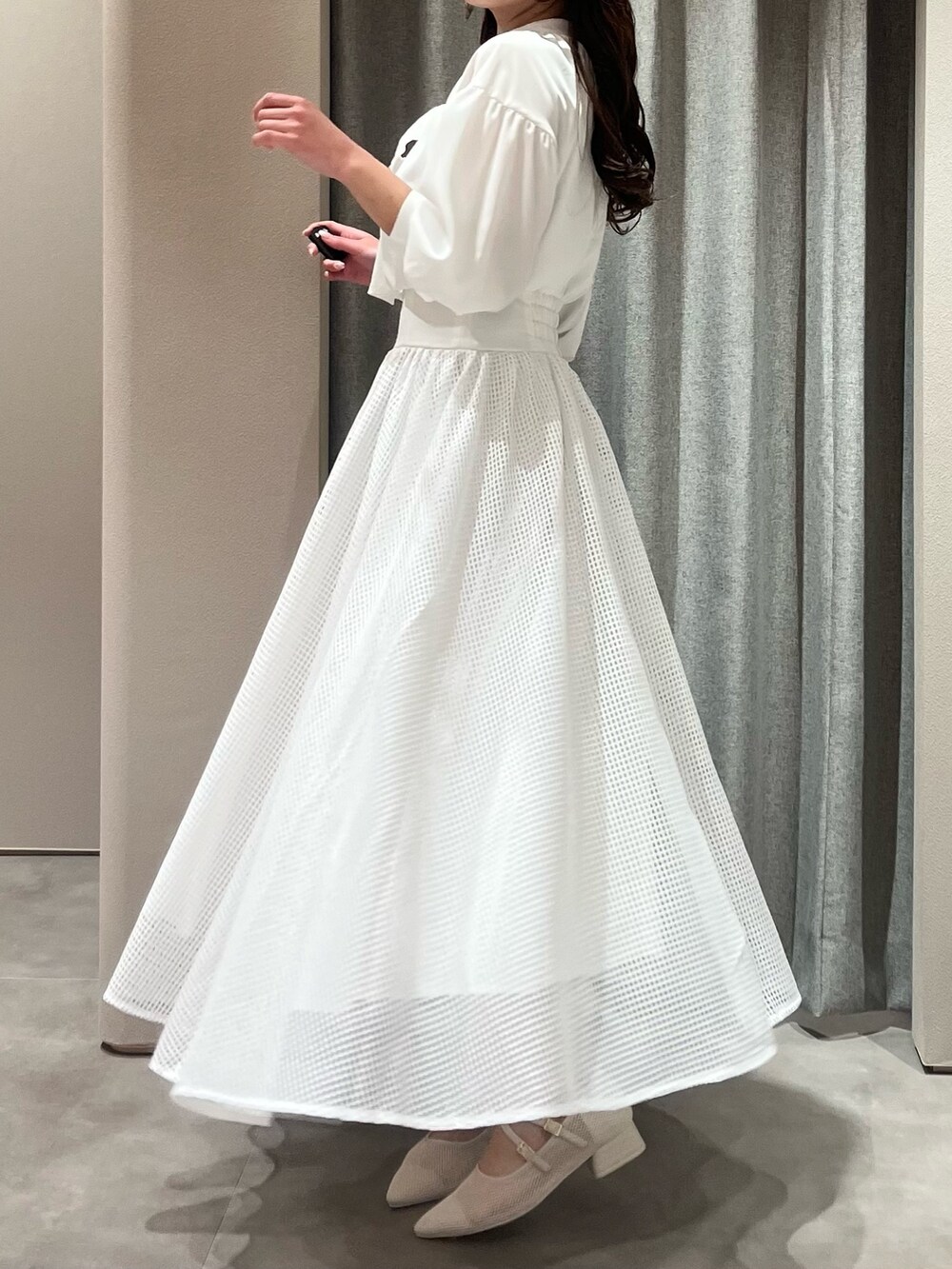 ホワイト系のワンピース、ホワイト系のパンプスを着用したレディースの春コーディネートの6枚目の写真