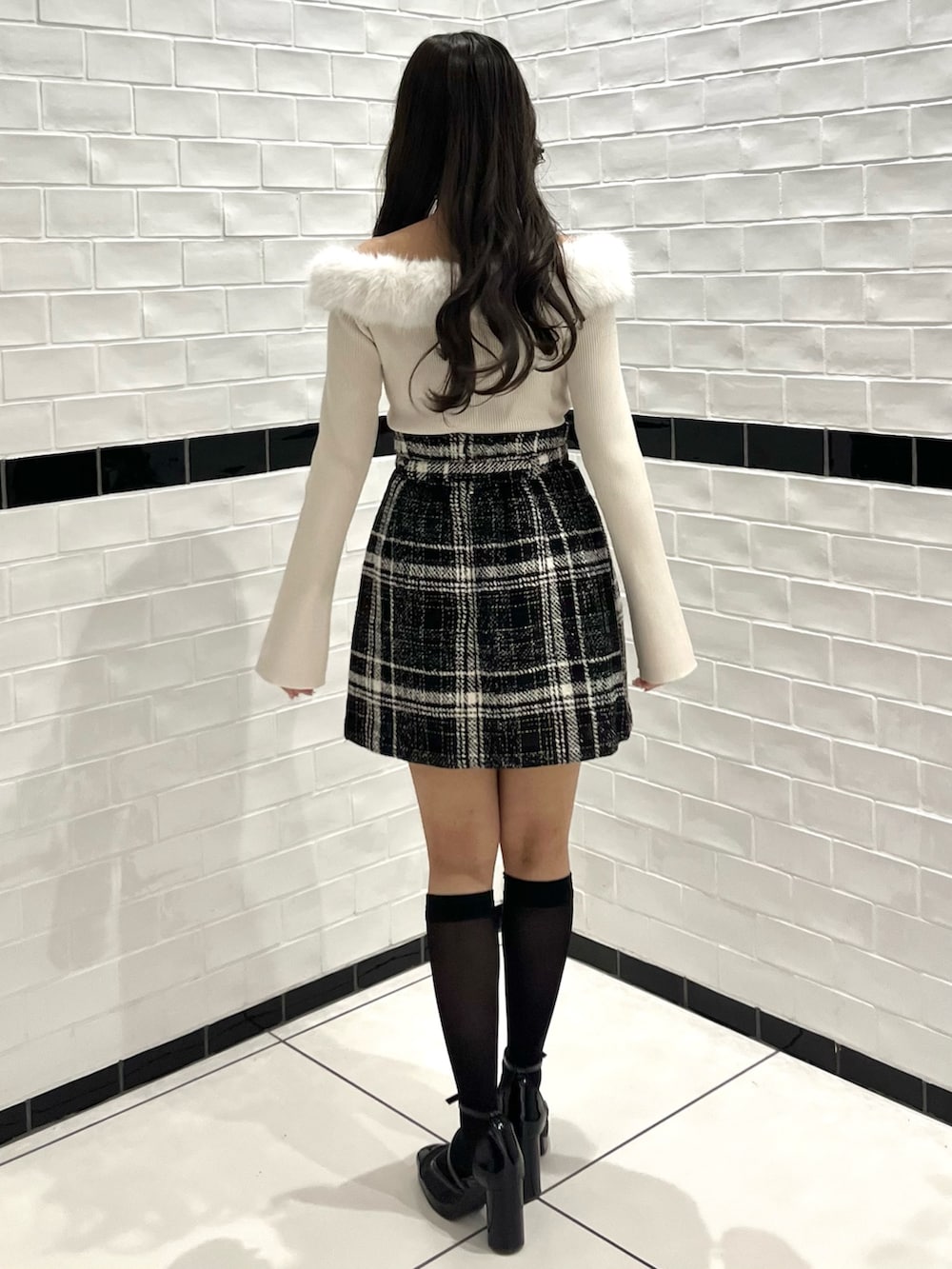 ベージュ系のニット/セーター、ブラック系のスカート、ブラック系のパンプスを着用したレディースの冬コーディネートの8枚目の写真