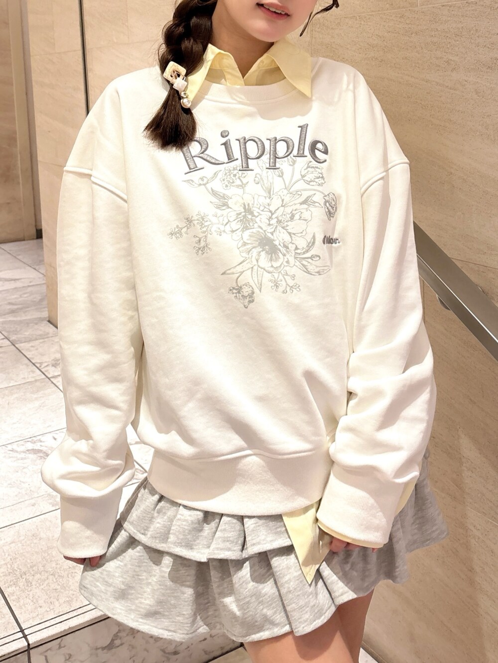 ホワイト系のスウェット、イエロー系のシャツ/ブラウス、グレー系のスカートを着用したレディースの春コーディネートの9枚目の写真