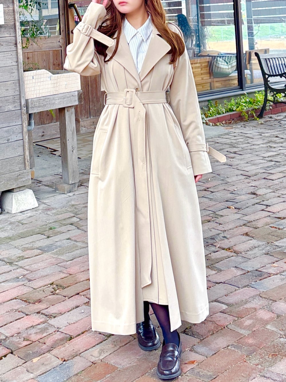 ベージュ系のトレンチコートを着用したレディースの春コーディネートの4枚目の写真