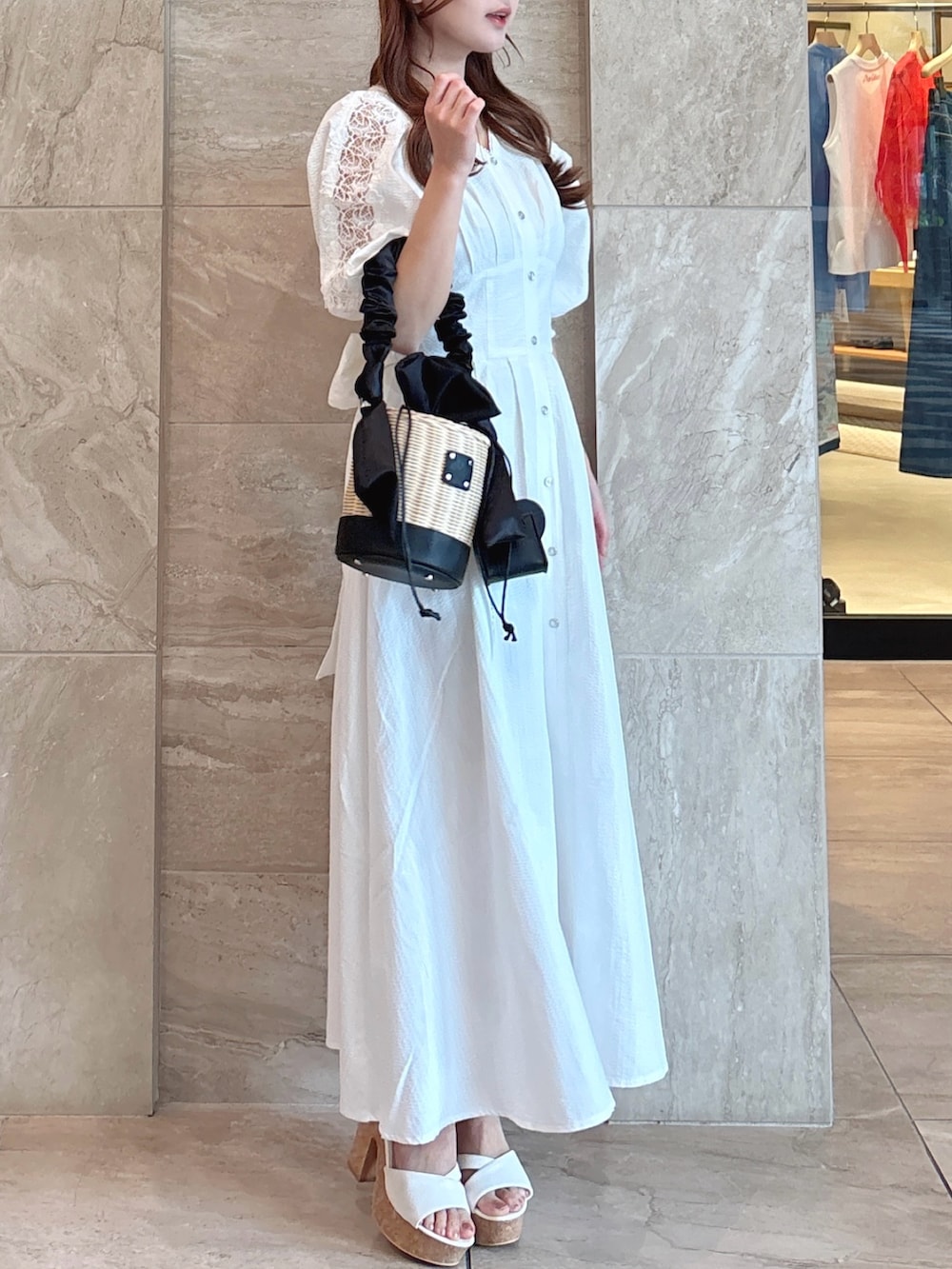 ホワイト系のワンピース、ブラック系のかごバッグ、ホワイト系のサンダルを着用したレディースの夏コーディネートの5枚目の写真