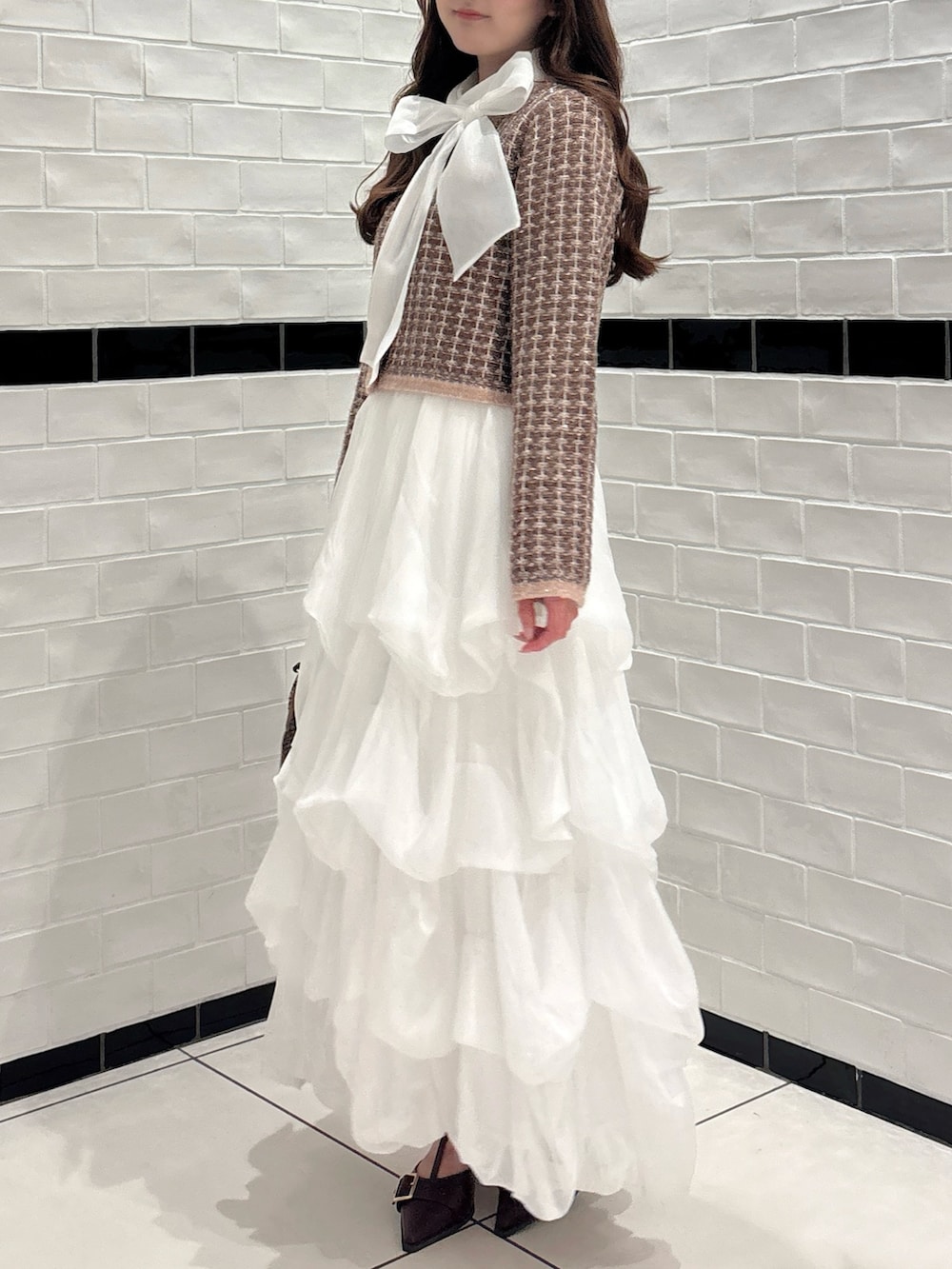 ブラウン系のカーディガン/ボレロ、ホワイト系のシャツ/ブラウス、ブラウン系のショルダーバッグを着用したレディースの秋コーディネートの7枚目の写真