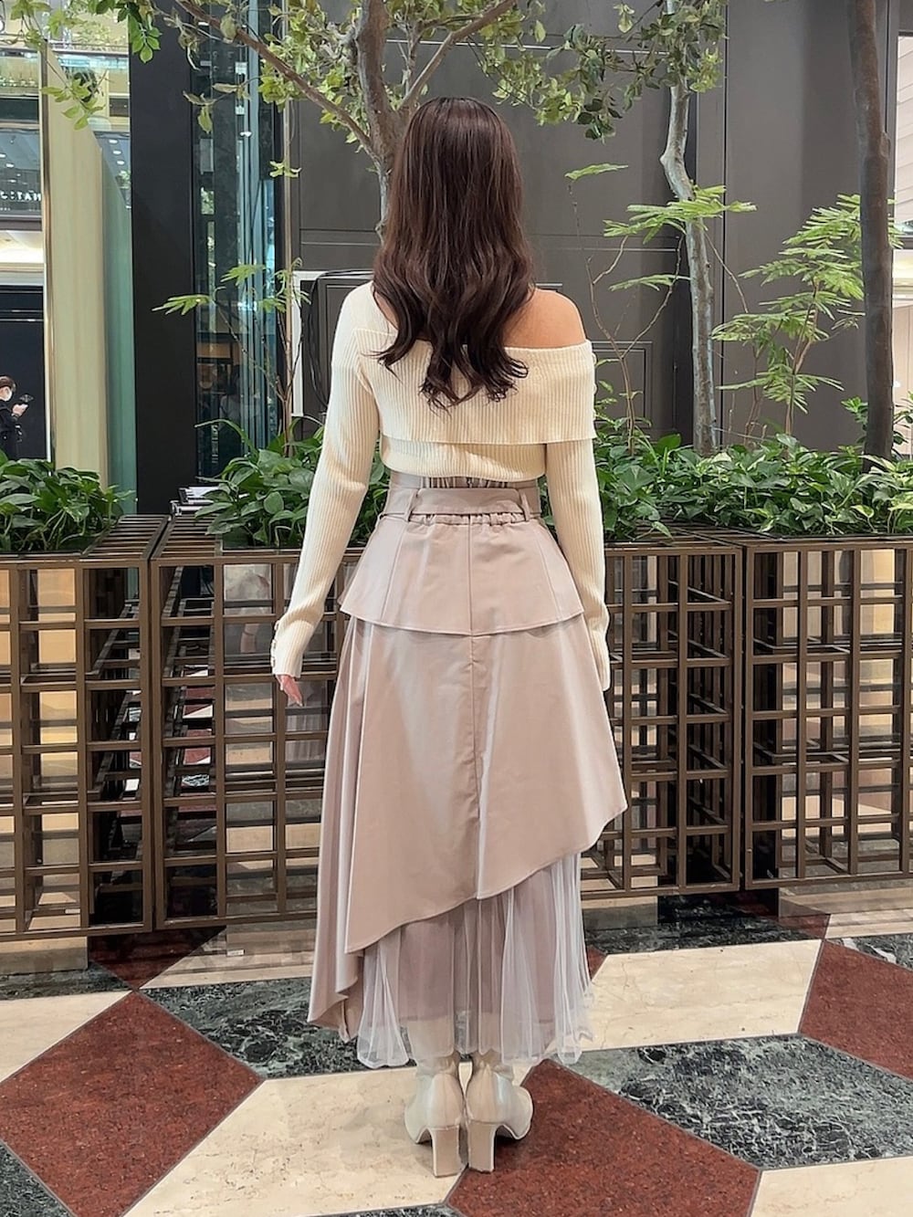 ホワイト系のニット/セーター、ベージュ系のスカート、ホワイト系のブーツを着用したレディースの冬コーディネートの4枚目の写真