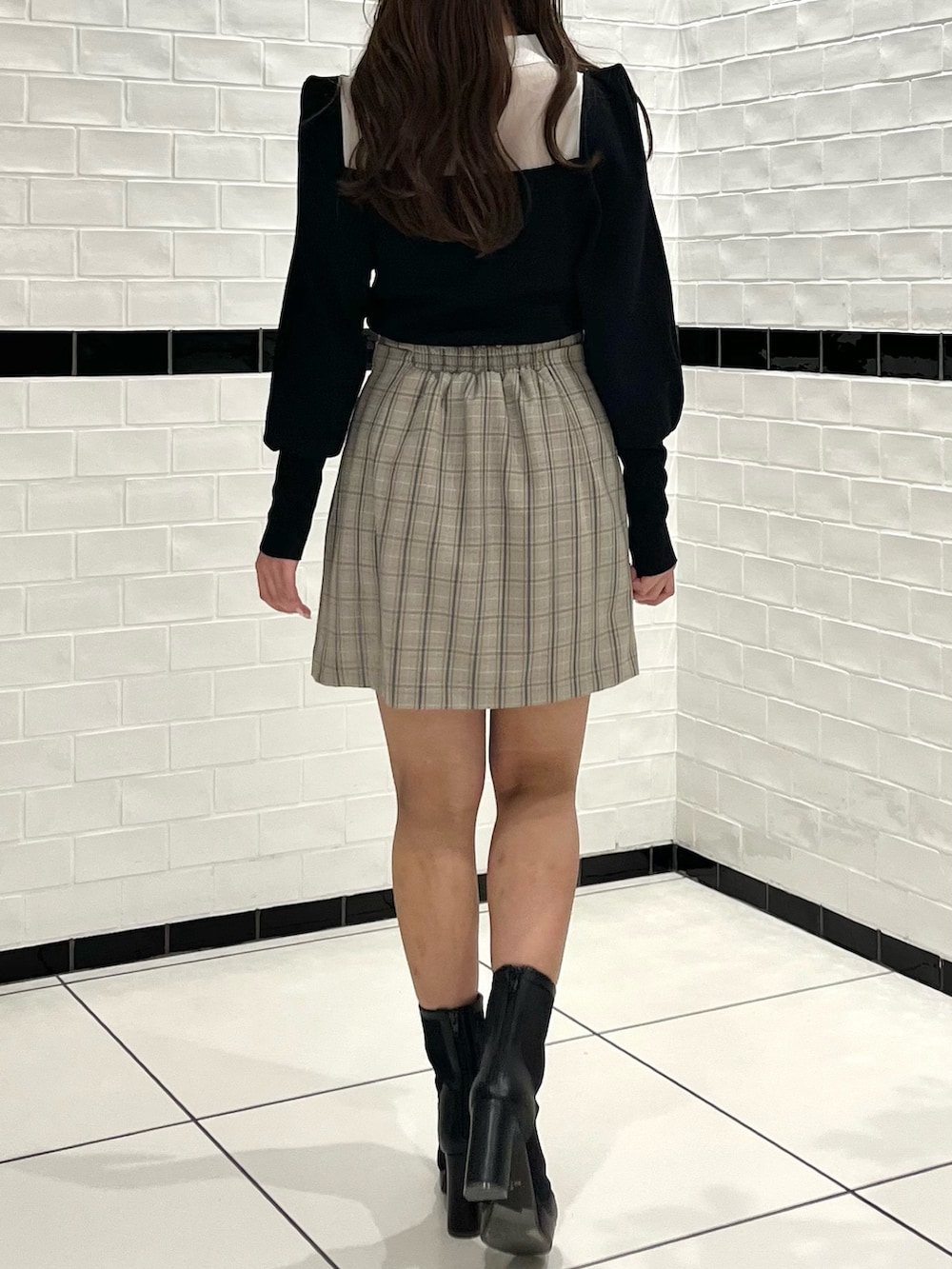 ブラック系のニット/セーター、その他のスカート、ブラック系のブーツを着用したレディースの冬コーディネートの7枚目の写真