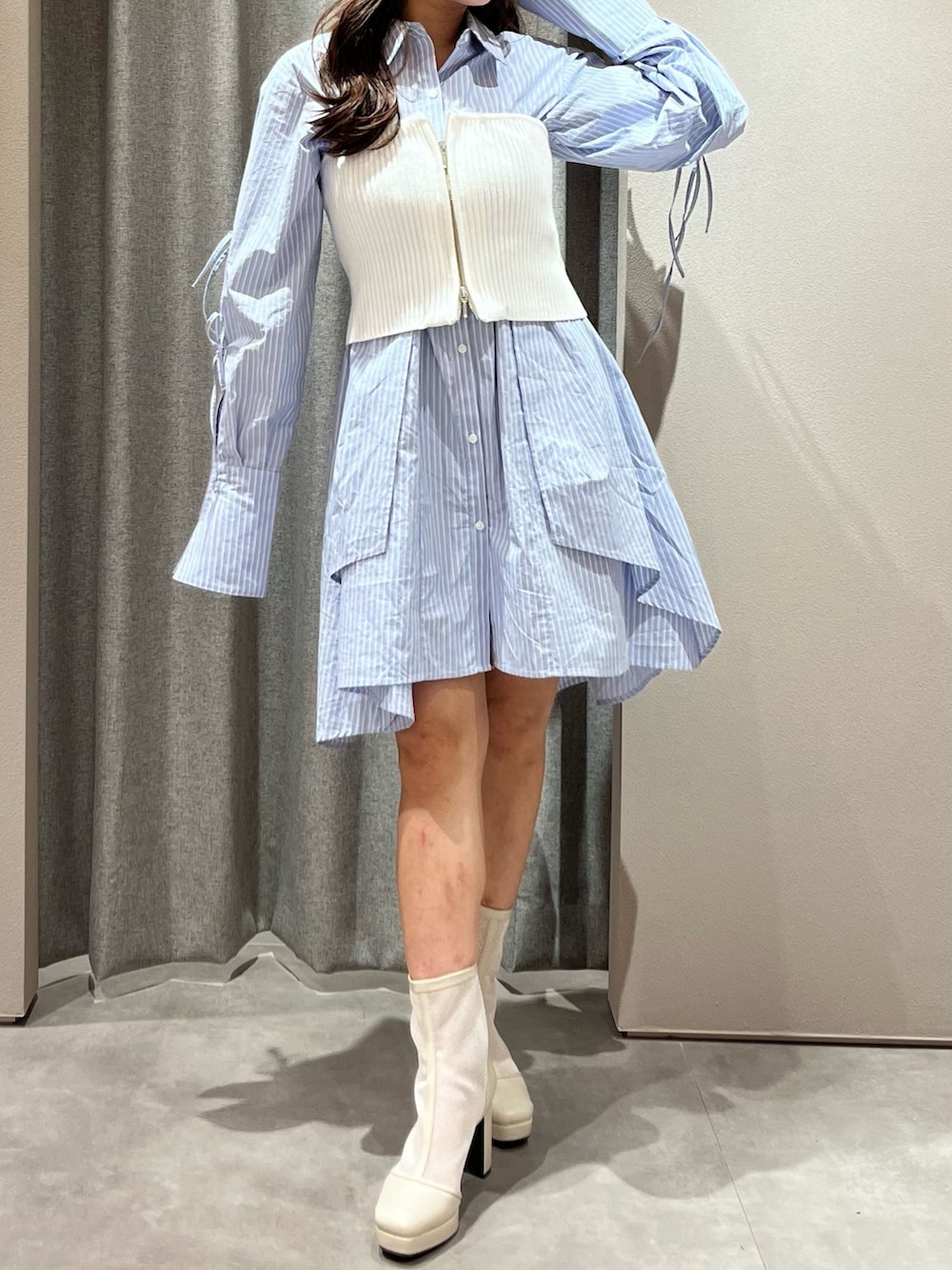 ホワイト系のキャミソール、ブルー系のシャツワンピース、ホワイト系のブーツを着用したレディースの冬コーディネートの3枚目の写真