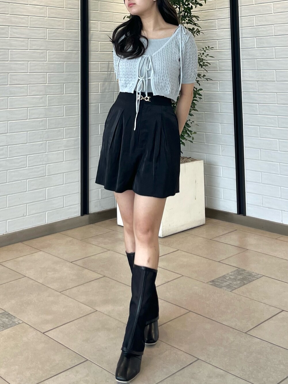 グレー系のニット/セーター、ブラック系のその他パンツ、ブラック系のブーツを着用したレディースの夏コーディネートの2枚目の写真