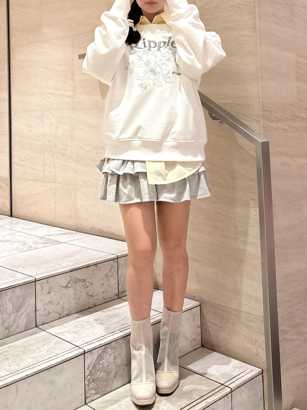 ホワイト系のスウェット、イエロー系のシャツ/ブラウス、グレー系のスカートを着用したレディースの春コーディネートの3枚目の写真