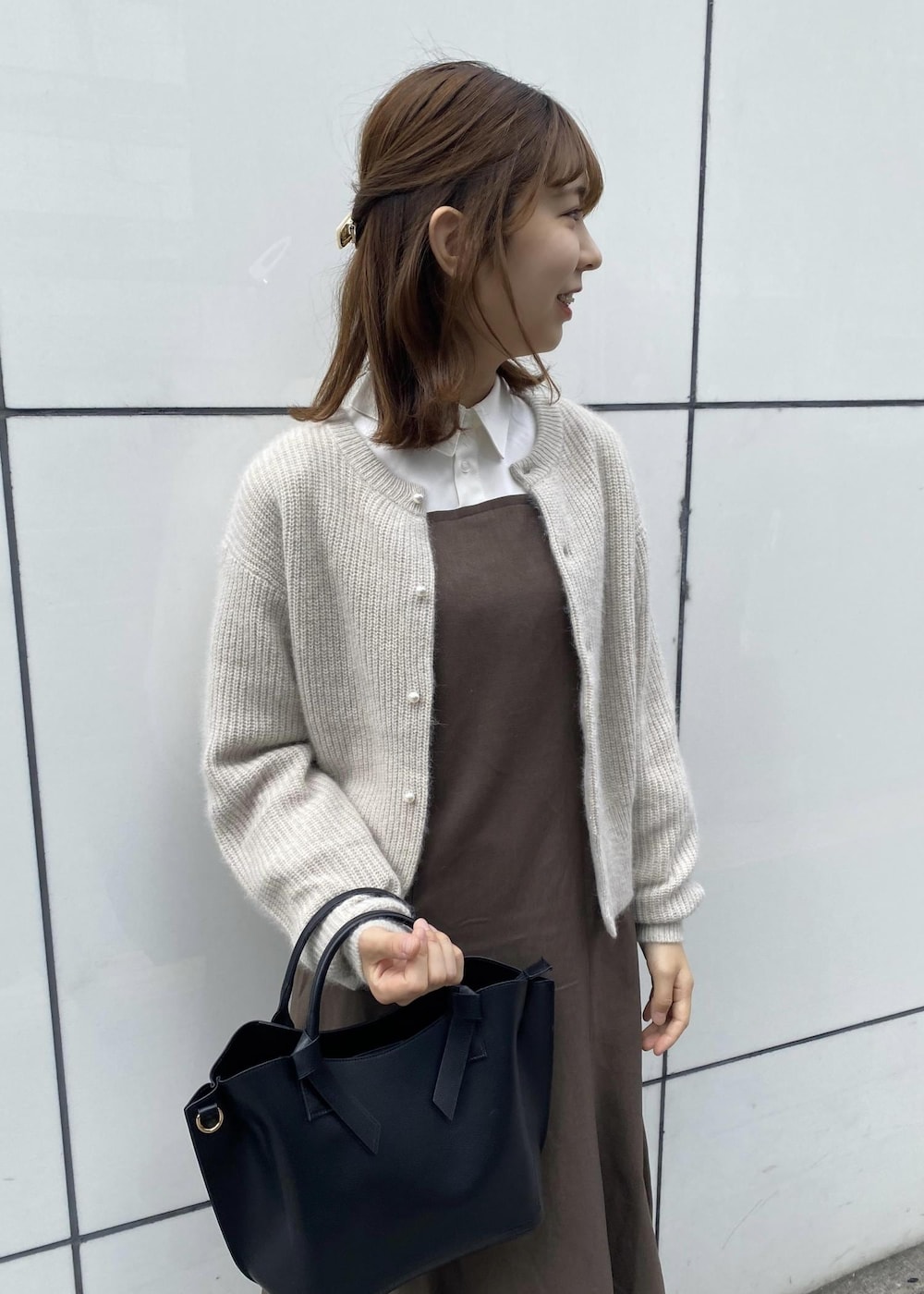 ホワイト系のブーツ、ホワイト系のカーディガン/ボレロ、ブラウン系のワンピースを着用したレディースの秋コーディネートの2枚目の写真