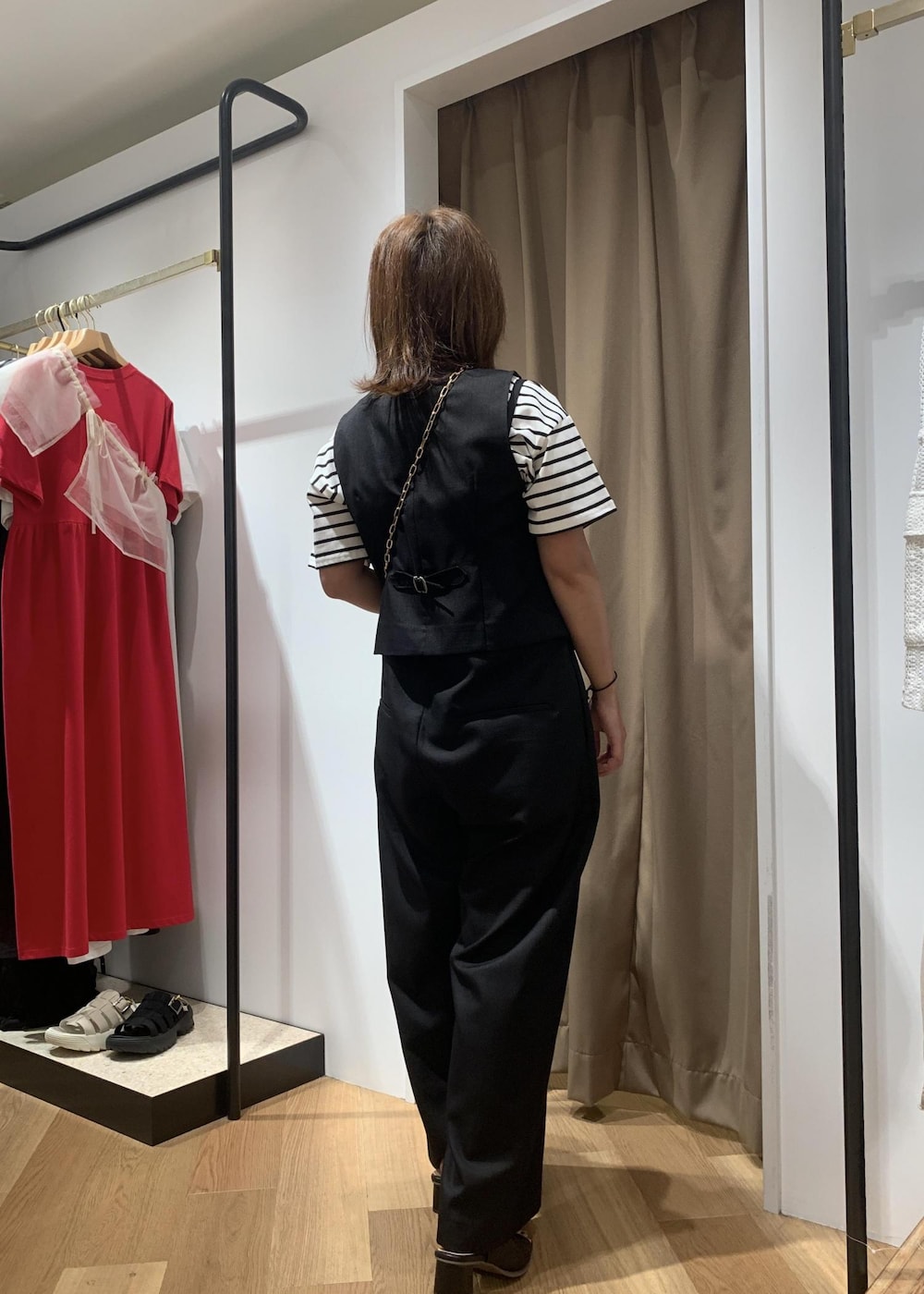 ブラック系のサンダル、ブラック系のショルダーバッグ、ホワイト系のTシャツ/カットソーを着用したレディースの夏コーディネートの3枚目の写真