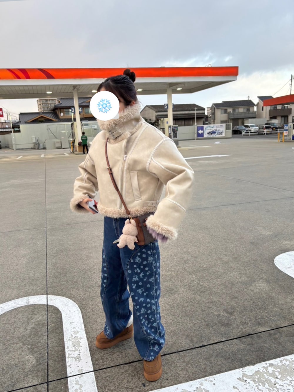 ホワイト系のムートンコート、ブルー系のデニムパンツ、イエロー系のブーツを着用したレディースの冬コーディネートの2枚目の写真