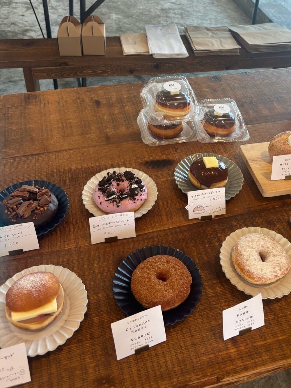 ブルー系のハンドバッグ、ブラック系のデニムパンツ、ホワイト系のスニーカーを着用したレディースの春コーディネートの2枚目の写真