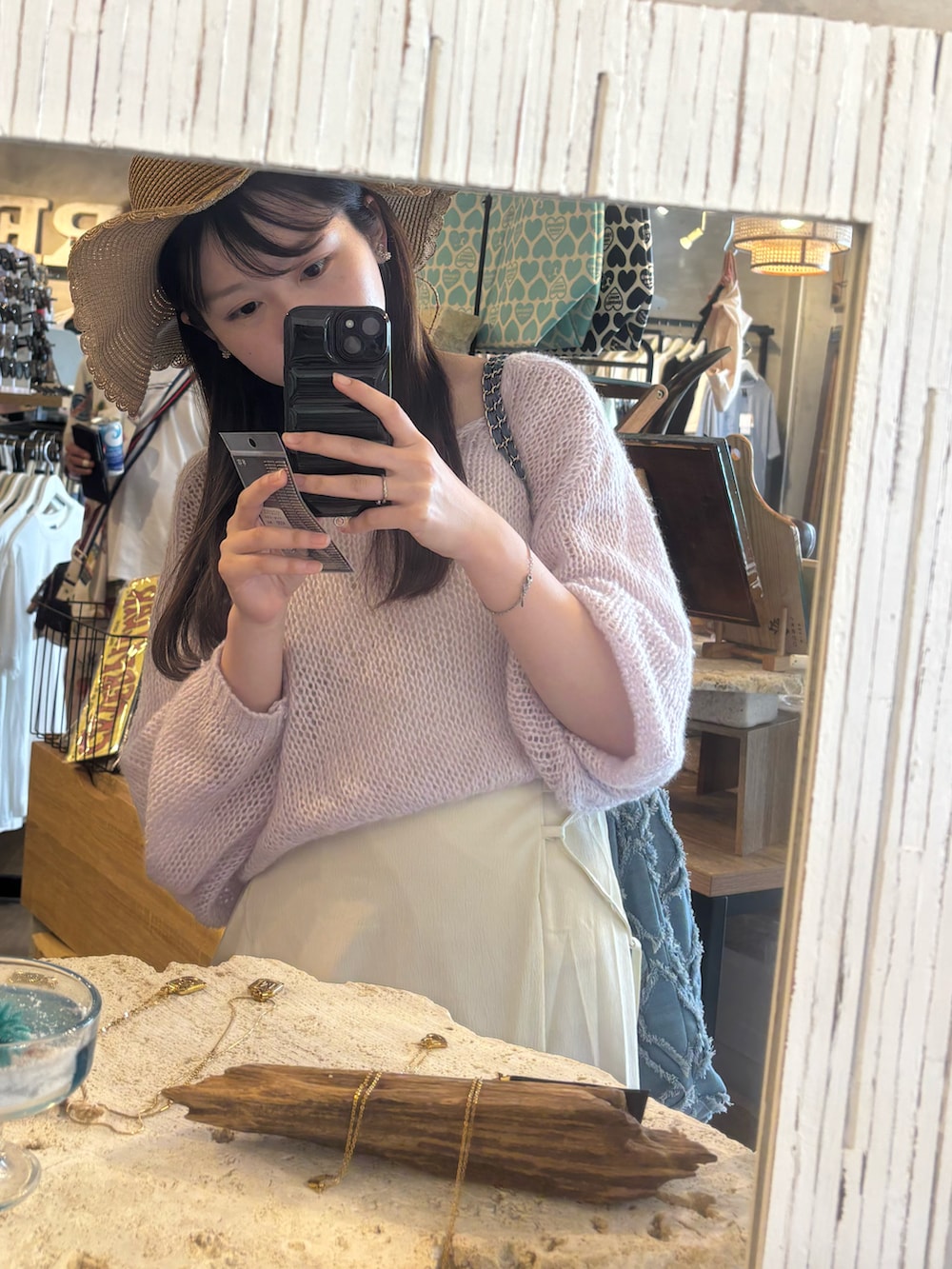 ピンク系のニット/セーター、ホワイト系のワンピース/ドレス、ホワイト系のサンダルを着用したレディースの春コーディネートの2枚目の写真