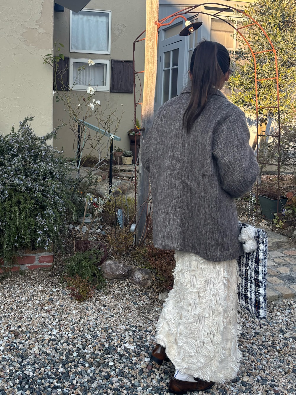 ホワイト系のTシャツ/カットソー、ホワイト系のニット/セーター、ブラウン系のテーラードジャケットを着用したレディースの冬コーディネートの2枚目の写真