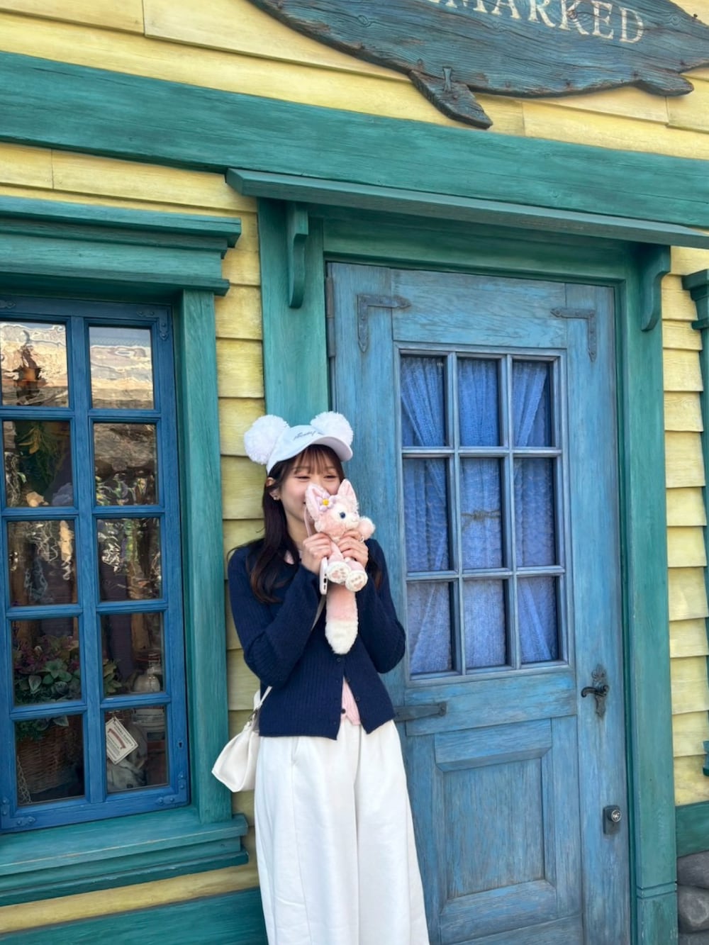 ホワイト系のスウェットパンツ、ベージュ系のスニーカー、ホワイト系のショルダーバッグを着用したレディースの春コーディネートの2枚目の写真