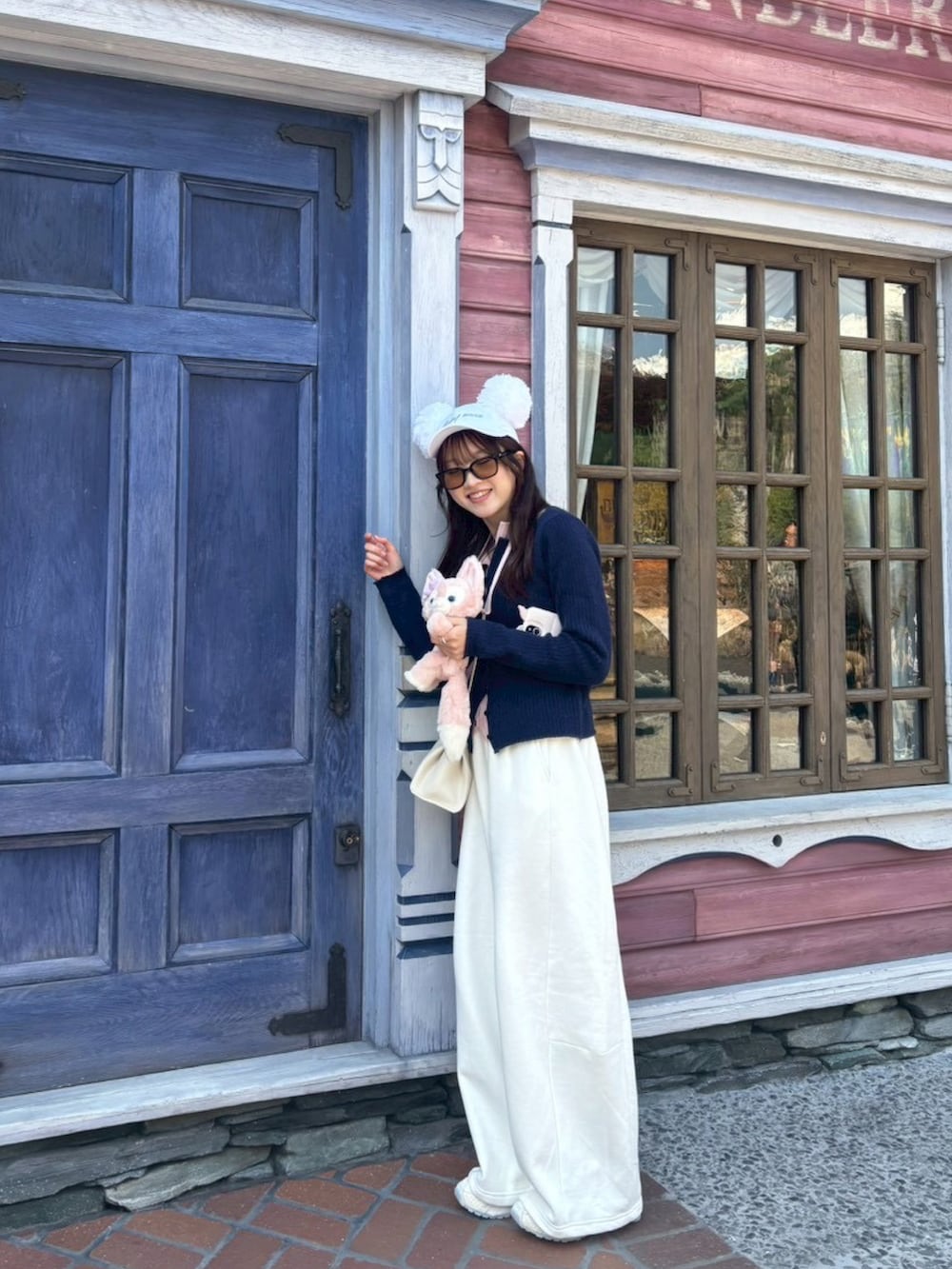 ホワイト系のスウェットパンツ、ベージュ系のスニーカー、ホワイト系のショルダーバッグを着用したレディースの春コーディネートの3枚目の写真