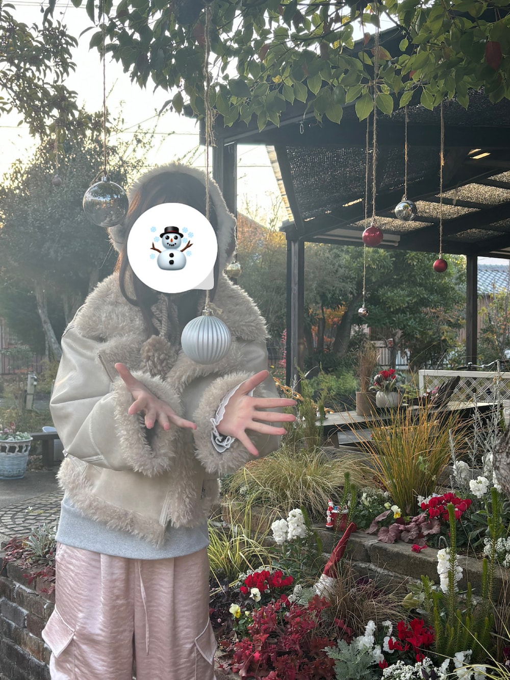 グレー系のTシャツ/カットソー、ピンク系のカーゴパンツ、ホワイト系のムートンコートを着用したレディースの冬コーディネートの3枚目の写真