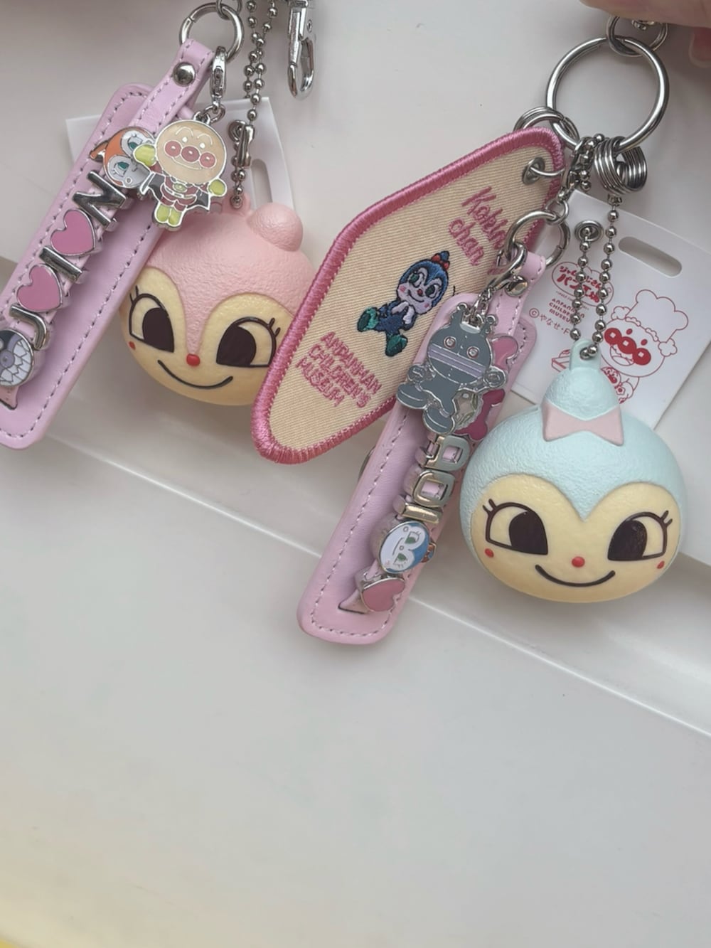 グレー系のニット/セーター、ホワイト系のTシャツ/カットソー、ベージュ系のショルダーバッグを着用したレディースの春コーディネートの3枚目の写真