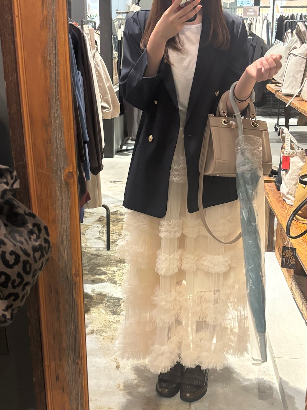 ホワイト系のスカートを着用したレディースの秋コーディネートの2枚目の写真