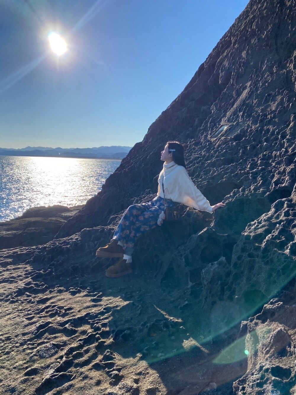 イエロー系のブーツ、ブラウン系のショルダーバッグ、ホワイト系のニット/セーターを着用したレディースの冬コーディネートの4枚目の写真