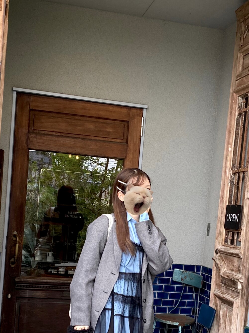 ブラック系のワンピース、ホワイト系のショルダーバッグ、ブルー系のシャツ/ブラウスを着用したレディースの春コーディネートの2枚目の写真