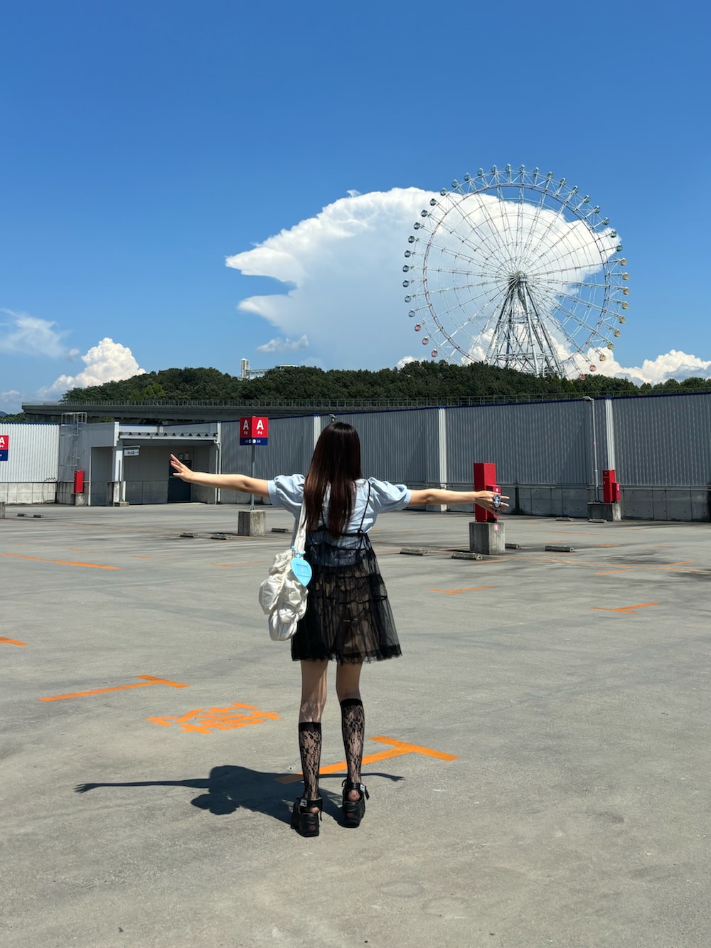 ブルー系のシャツ/ブラウス、ブラック系のワンピース、ブラック系のサンダルを着用したレディースの夏コーディネートの2枚目の写真