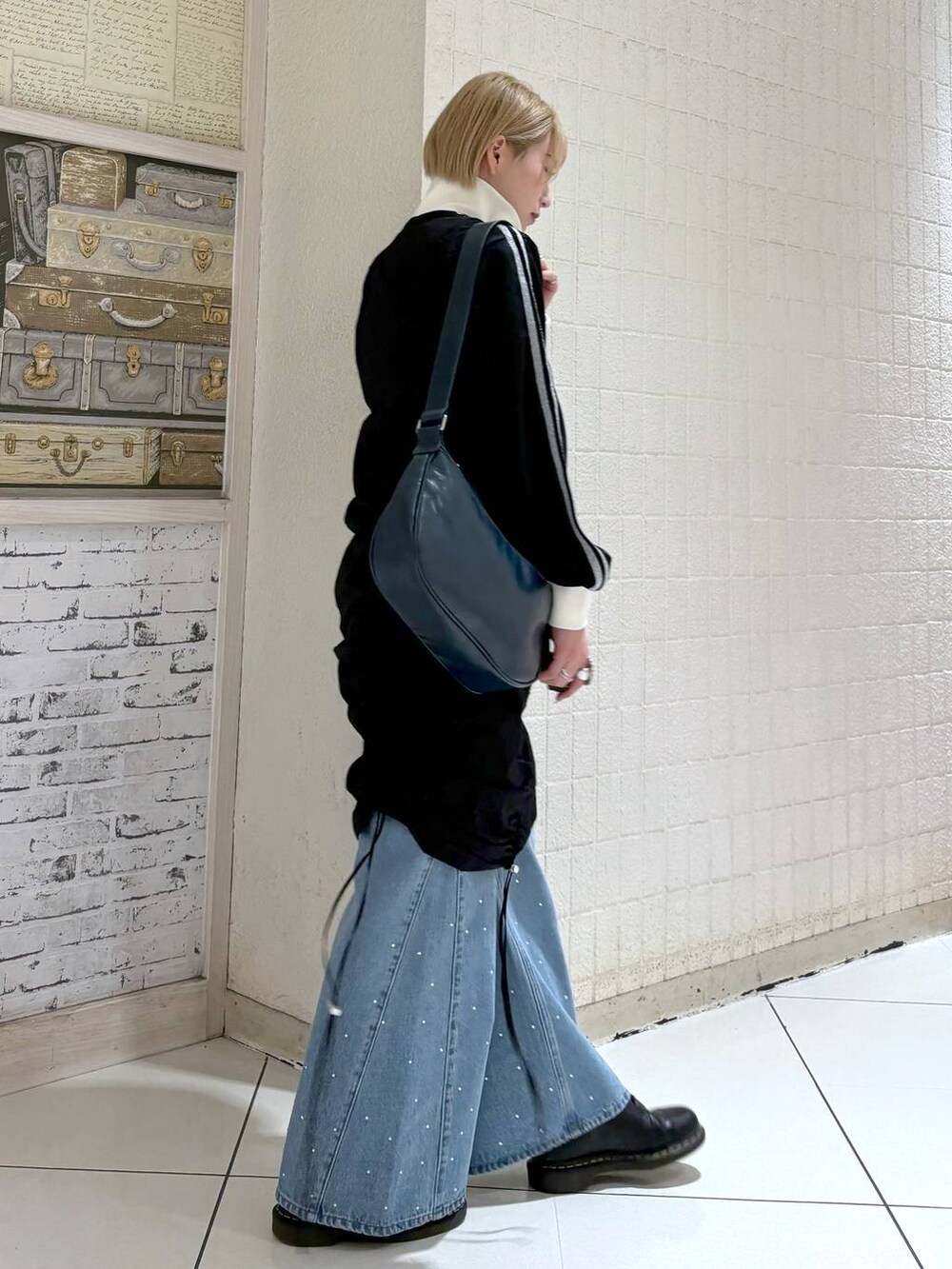 ブラック系のワンピース、ブルー系のショルダーバッグ、ブラック系のジャージを着用したレディースの冬コーディネートの4枚目の写真