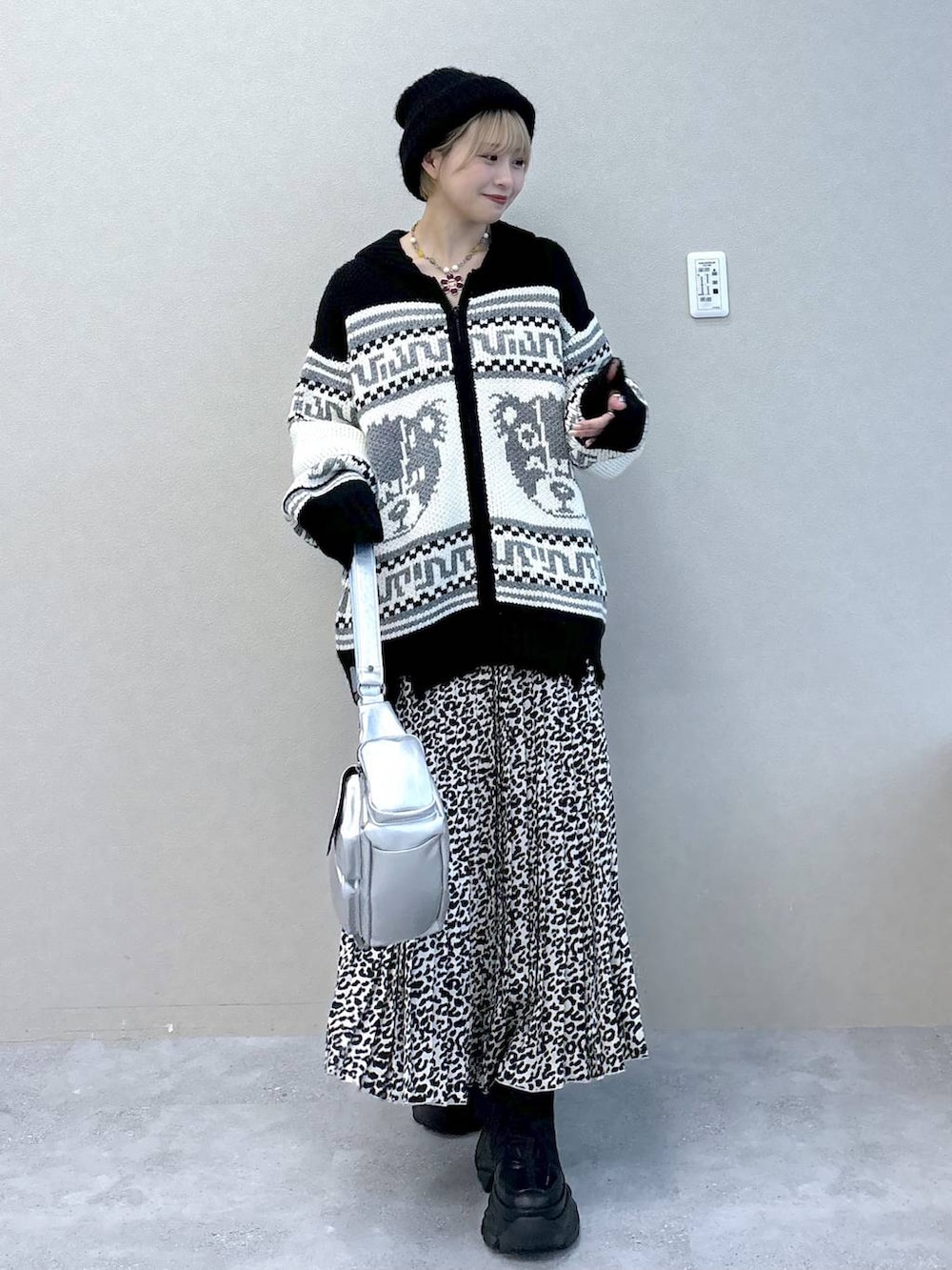 シルバー系のショルダーバッグ、ブラック系のブーツ、ブラック系のカーディガン/ボレロを着用したレディースの秋コーディネートの2枚目の写真