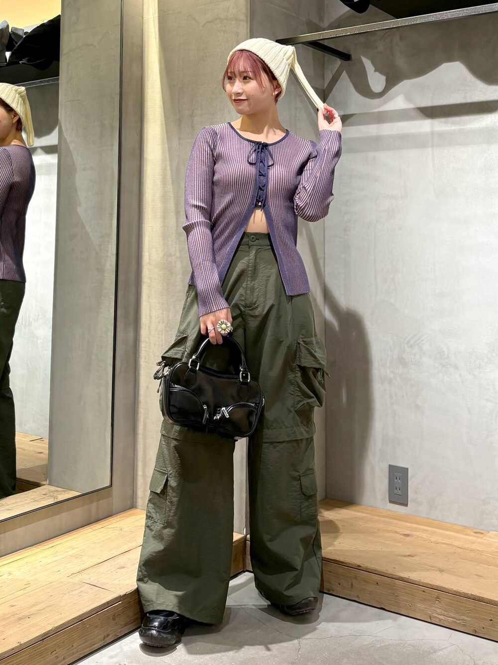 ブルー系のニット/セーター、ブラック系のボストンバッグ、グリーン系のカーゴパンツを着用したレディースの冬コーディネートの3枚目の写真