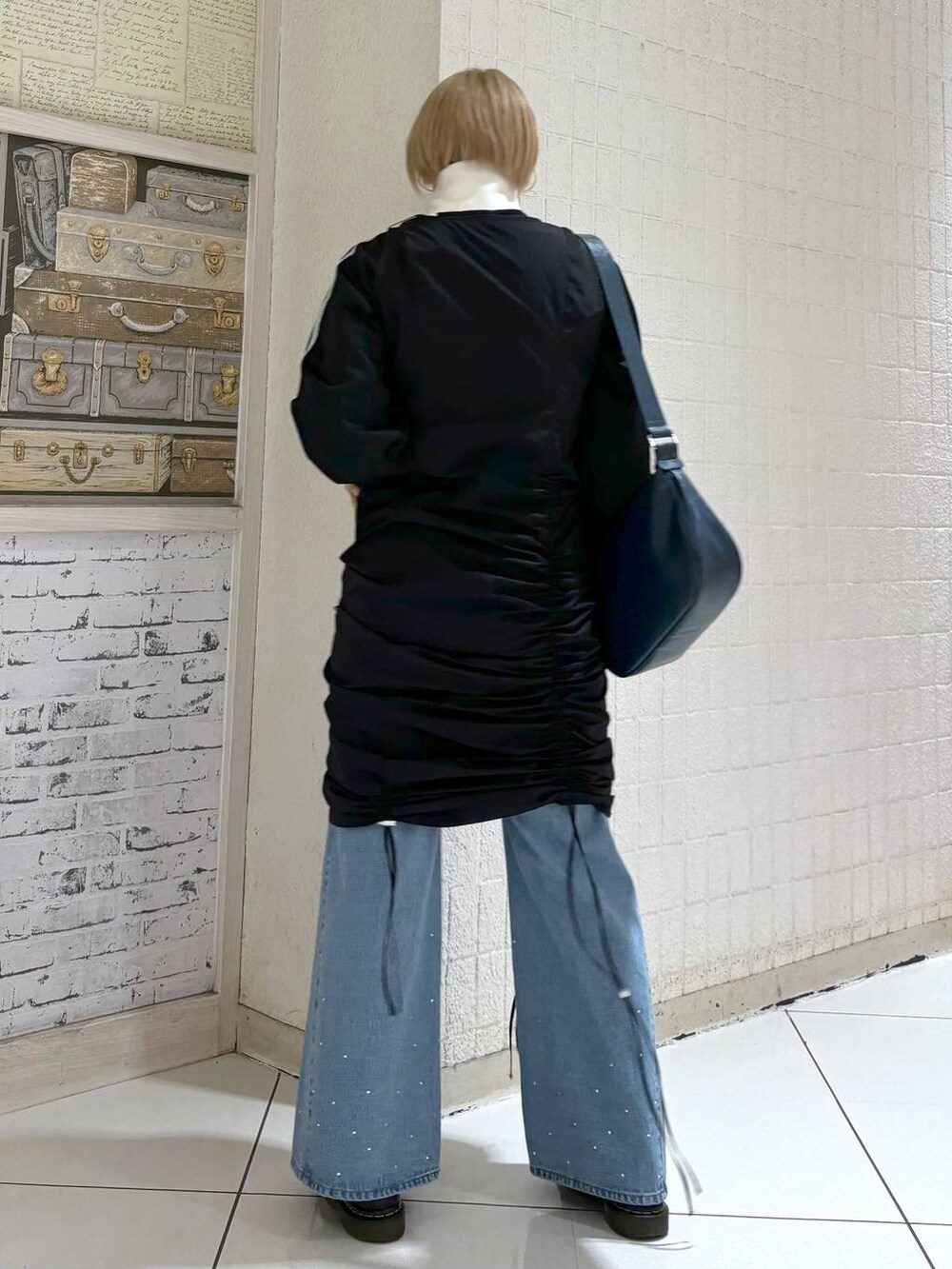 ブラック系のワンピース、ブルー系のショルダーバッグ、ブラック系のジャージを着用したレディースの冬コーディネートの3枚目の写真