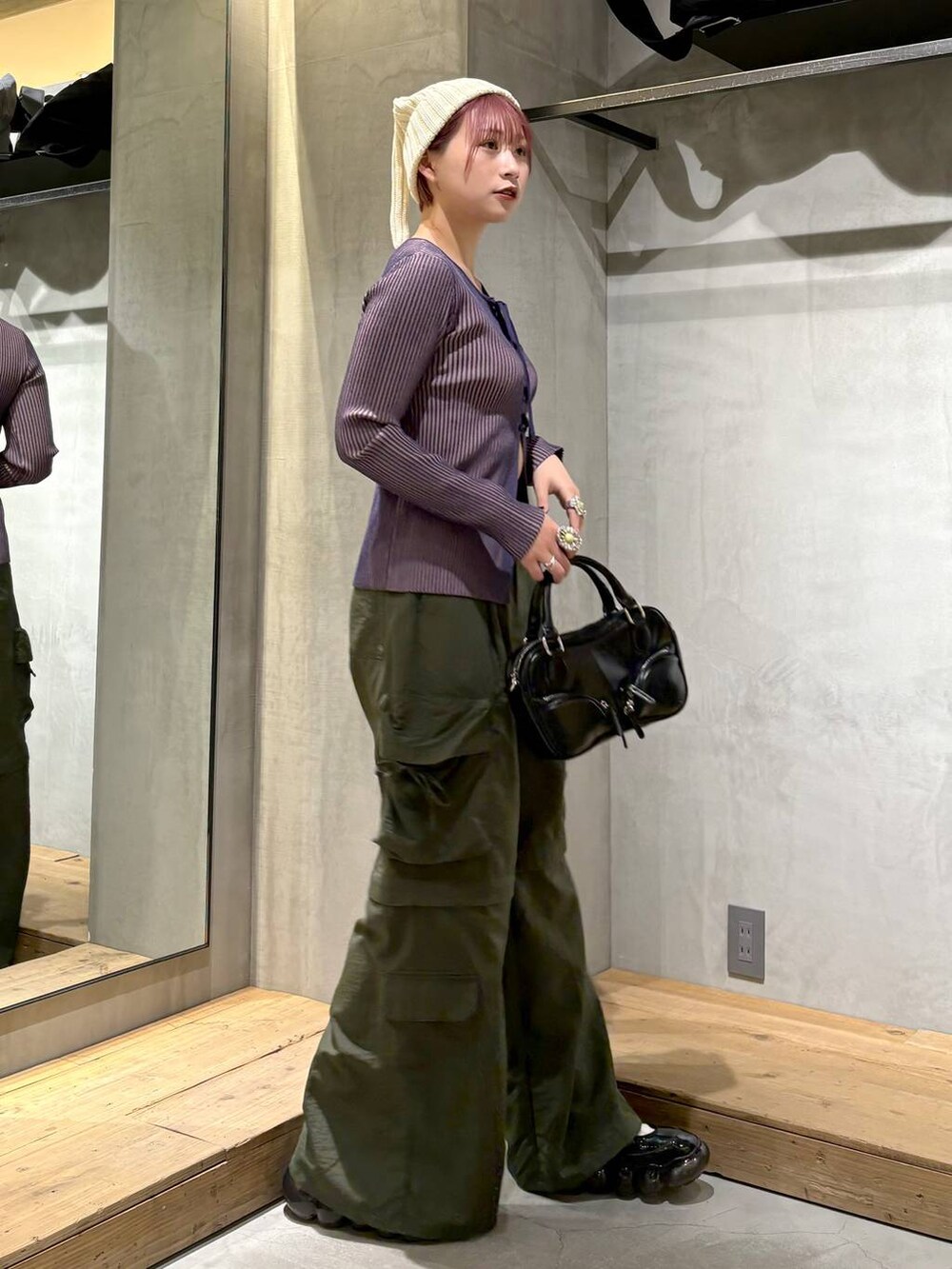 ブルー系のニット/セーター、ブラック系のボストンバッグ、グリーン系のカーゴパンツを着用したレディースの冬コーディネートの4枚目の写真