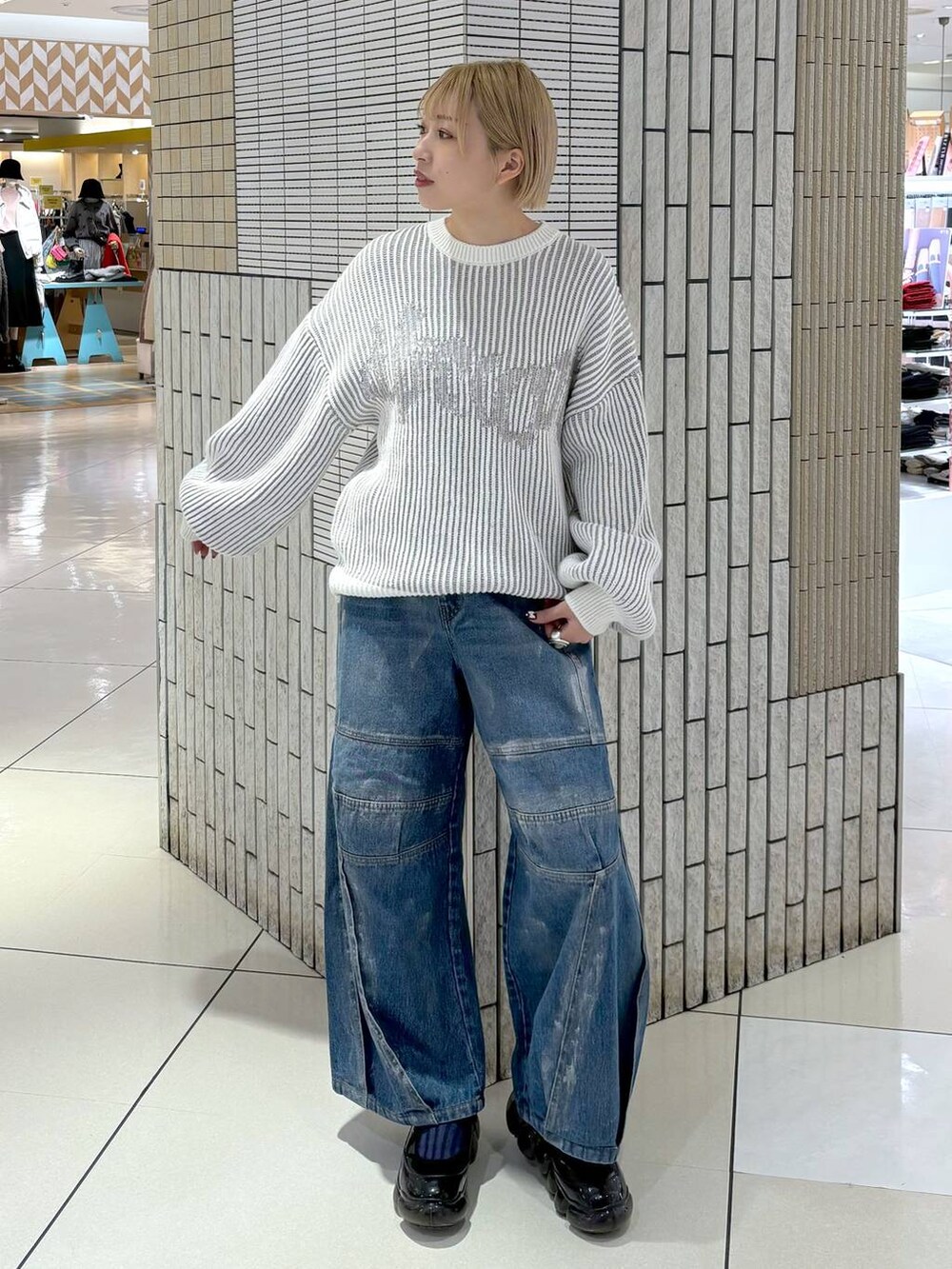 ブルー系のデニムパンツ、ホワイト系のニット/セーターを着用したレディースの冬コーディネートの2枚目の写真